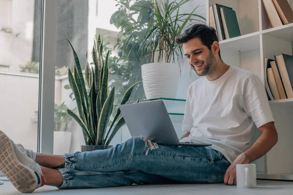 stock image young man at home with computer and cup of coffee