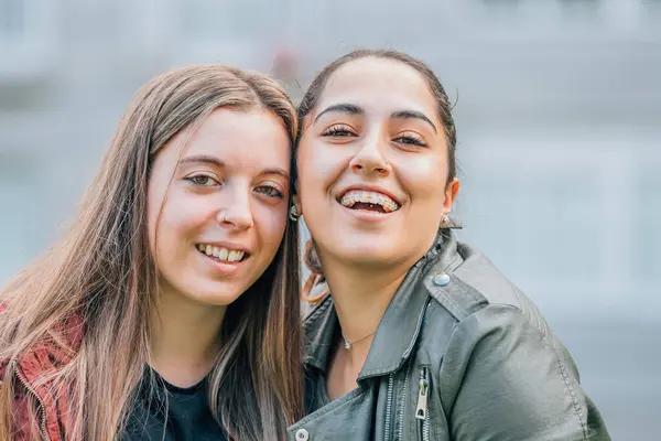 couple of girls friends smiling on the street