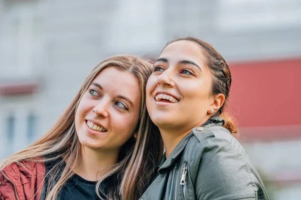 couple of girls friends smiling on the street