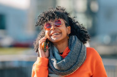 Sokaktaki kız konuşuyor ya da cep telefonuyla arıyor.