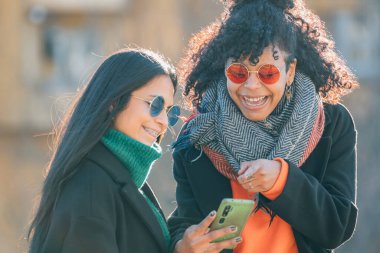 Sokaktaki arkadaşlar cep telefonuna bakıyor.