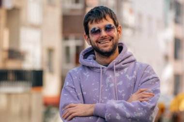 Güneş gözlüklü ve sakallı genç bir adamın portresi.