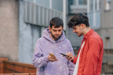 young men on the street with mobile phones