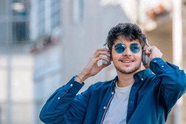 Kulaklık ve güneş gözlüklü çocuk.