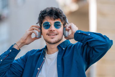 Kulaklık ve güneş gözlüklü çocuk.