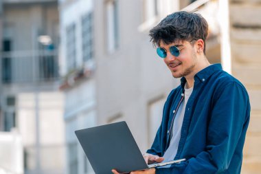 Açık havada dizüstü bilgisayarı olan üniversite öğrencisi.