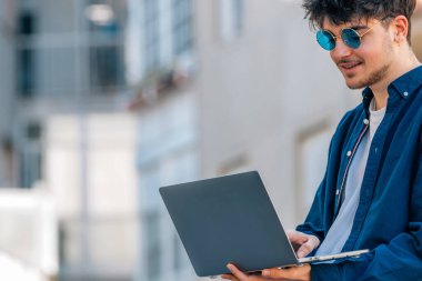 Açık havada dizüstü bilgisayarı olan üniversite öğrencisi.