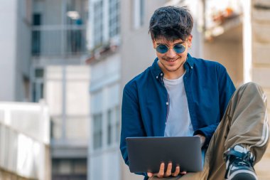 Açık havada dizüstü bilgisayarı olan üniversite öğrencisi.