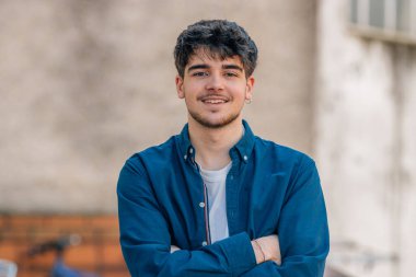 Dışarıda gülümseyen genç bir erkek portresi.
