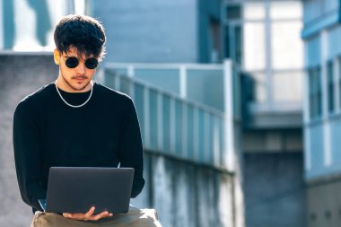 Sokakta dizüstü bilgisayarı olan genç bir adam