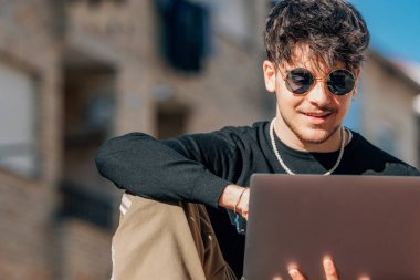 Sokakta dizüstü bilgisayarı olan genç bir adam