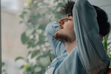 Genç adam evde dinleniyor.