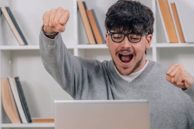 Bilgisayarda heyecanlı öğrenci sevinçle kutluyor