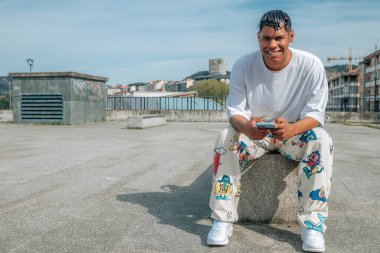 Şehir caddesinde cep telefonu olan genç bir Latin.