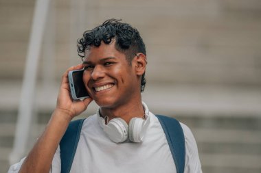 Sokaktaki genç Latin erkek cep telefonuyla konuşuyor.