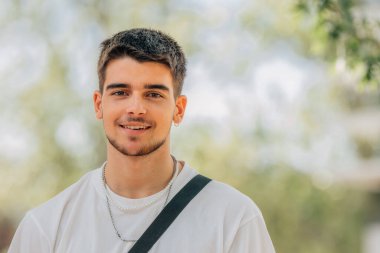 Dışarıdaki genç adamın gülümseyen portresi.