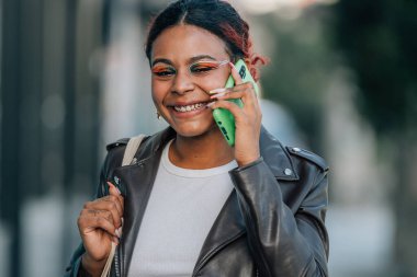 Kız cep telefonuyla konuşuyor. Sokakta yürüyor.