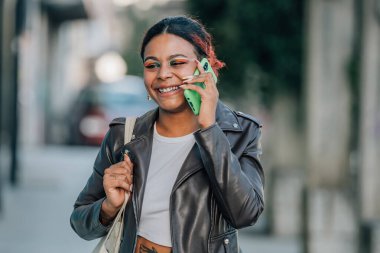 Kız cep telefonuyla konuşuyor. Sokakta yürüyor.