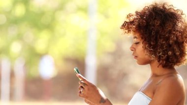 Dışarıda cep telefonu olan Afro-Amerikan Latin bir kadın.