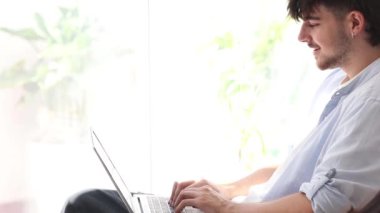 Dizüstü bilgisayarda fotokopi uzayıyla yazı yazan genç adam