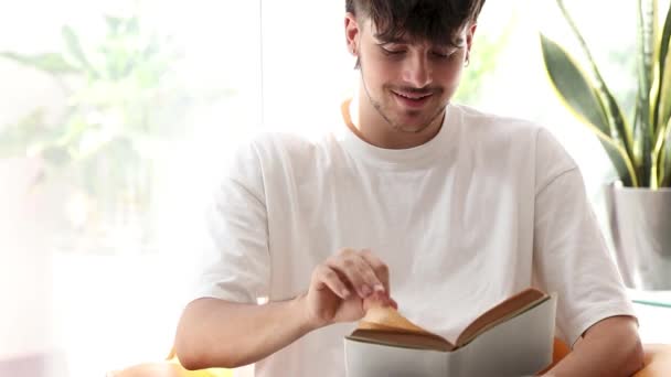 Junger Mann Der Ein Lehrbuch Studiert Oder Liest — Stockvideo