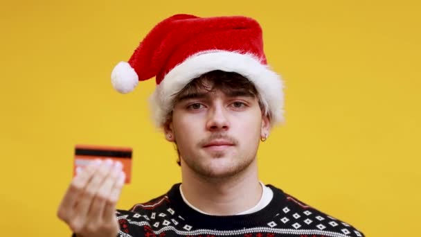Kaukasischer Junger Mann Mit Weihnachtsmann Hut Lächelt Und Hält Kreditkarte — Stockvideo
