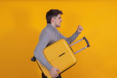 young man with suitcase isolated on background