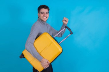 Renkli bavulu olan izole bir genç adam.