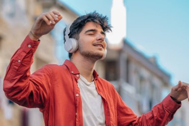 Kulaklıklı genç adam müzik dinlemekten zevk alıyor.