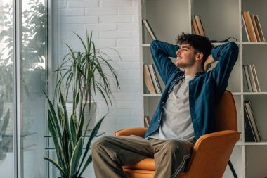 Genç adam evde kanepede rahatlatıcı