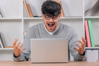 Öğrenci masadaki dizüstü bilgisayarla mutluluktan heyecanlanıyor