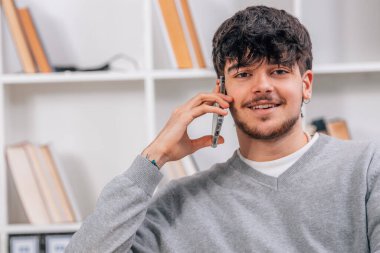 Cep telefonu ya da akıllı telefonu olan genç bir erkek öğrenci