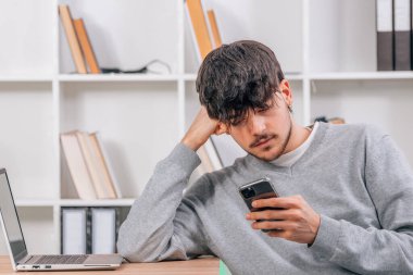 İçeride cep telefonuna ya da akıllı telefona bakan bir öğrenci