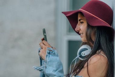 Şapkalı ve cep telefonlu hippi kız.