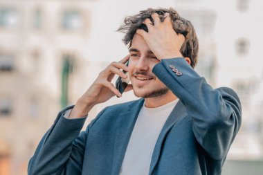 Çekici öğrenci sokakta cep telefonuyla konuşuyor.