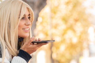 Cep telefonu olan kadın sesli mesaj gönderiyor