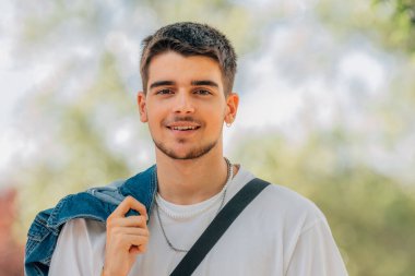 Dışarıdaki genç adamın gülümseyen portresi.