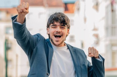 Sokaktaki genç erkek, başarı ya da kutlama ifadesiyle