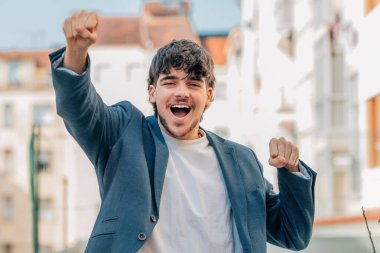 Sokaktaki genç erkek, başarı ya da kutlama ifadesiyle