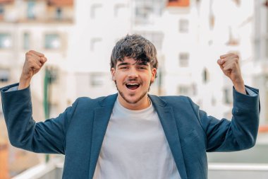 Sokaktaki genç erkek, başarı ya da kutlama ifadesiyle