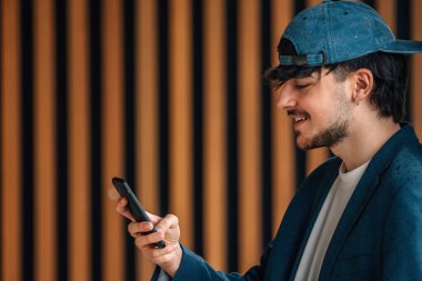 Sokakta cep telefonu olan bir öğrenci.