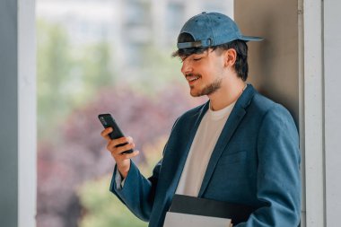 Sokakta cep telefonu olan bir öğrenci.