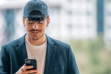 Çekici öğrenci sokakta cep telefonuyla konuşuyor.