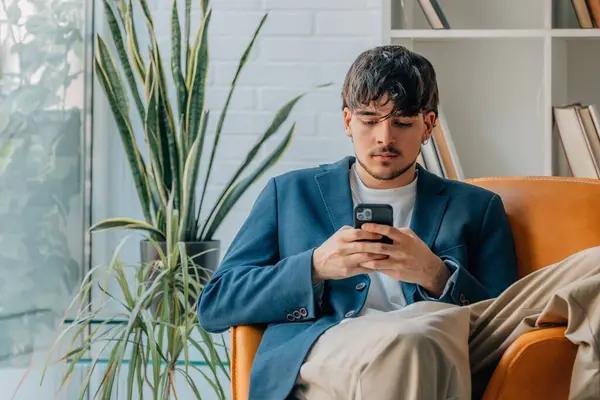 stock image young man sitting with mobile phone or smartphone