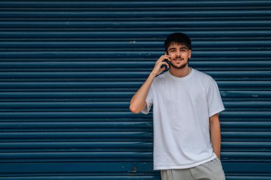 Cep telefonu ve cep telefonu olan genç bir adam.