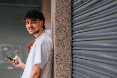 Cep telefonu ve cep telefonu olan genç bir adam.