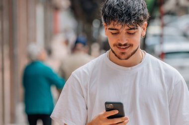 Cep telefonu ve cep telefonu olan genç bir adam.