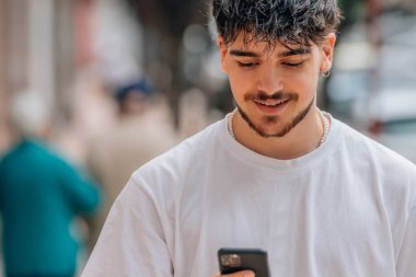 Cep telefonu ve cep telefonu olan genç bir adam.