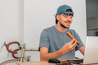 Bilgisayarlı öğrenci pizza yiyor.