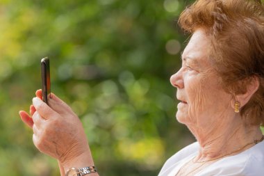 Dışarıda cep telefonu ya da akıllı telefon kullanan son sınıf öğrencisi.